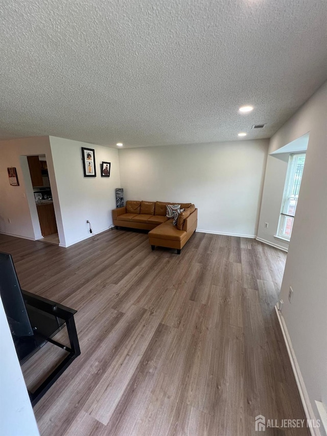 4108 Dilts Ln, Bridgewater, NJ 08807 - unfurnished living room with a textured ceiling, wood finished floors, and recessed lighting