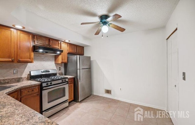 4108 Dilts Ln, Bridgewater, NJ 08807 - kitchen with stainless steel appliances, under cabinet range hood, brown cabinetry, decorative backsplash, and ceiling fan