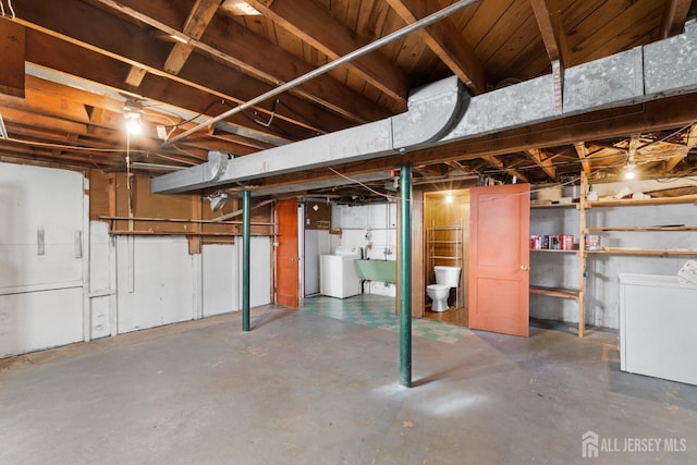 unfinished below grade area with a sink and separate washer and dryer