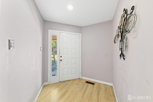 foyer entrance featuring visible vents, baseboards, and light wood-style floors