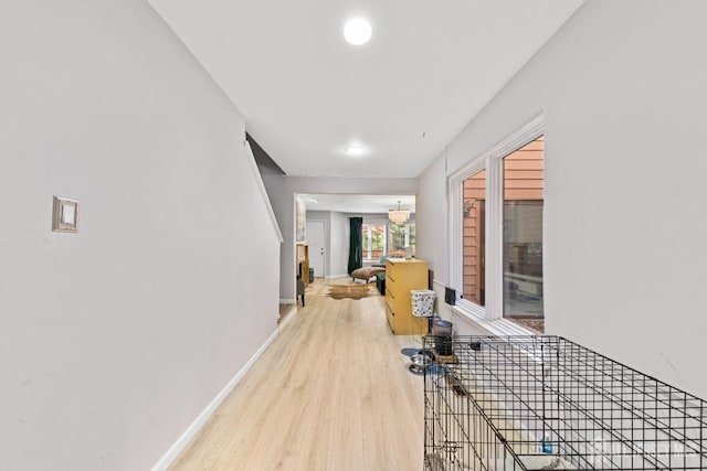 hallway with stairs, wood finished floors, and baseboards