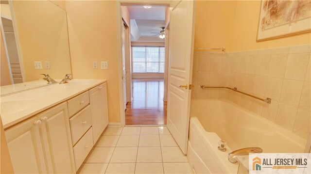 bathroom with tile patterned flooring, vanity, a bathing tub, and ceiling fan