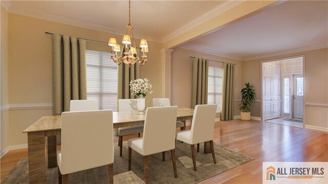 dining space with hardwood / wood-style flooring, a healthy amount of sunlight, and ornamental molding