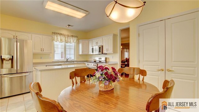 dining space with light tile patterned floors and sink