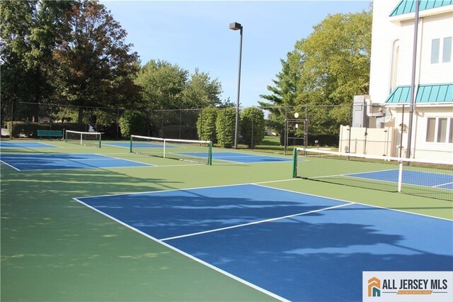 view of tennis court featuring basketball hoop