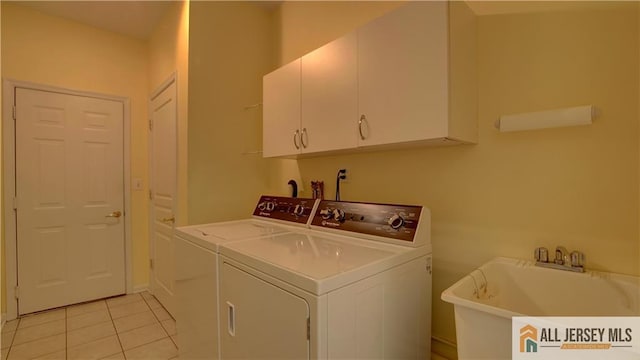 washroom featuring cabinets, washer and clothes dryer, sink, and light tile patterned floors