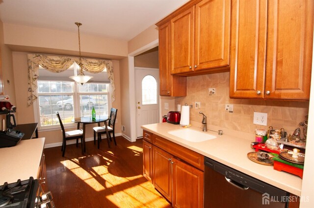 kitchen with dark hardwood / wood-style floors, pendant lighting, black dishwasher, sink, and decorative backsplash