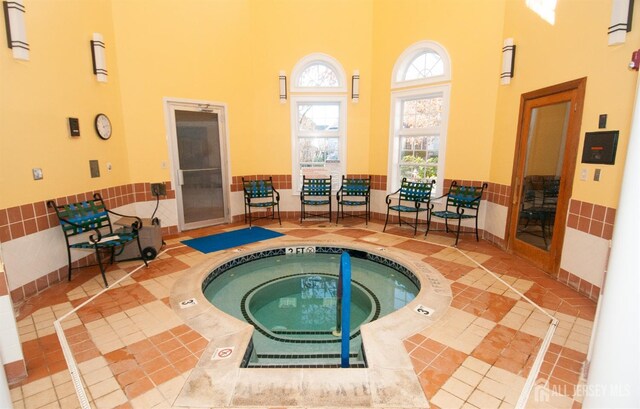 view of swimming pool with an indoor hot tub