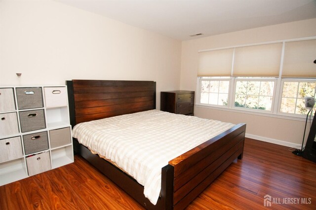 bedroom with dark hardwood / wood-style flooring