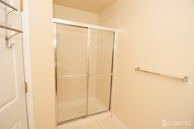 bathroom with tile patterned flooring and walk in shower