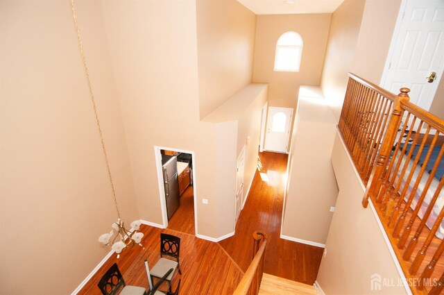 stairs featuring hardwood / wood-style flooring and a towering ceiling