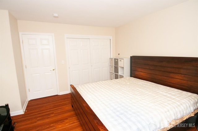 bedroom with dark wood-type flooring and a closet