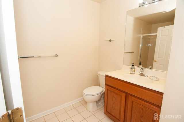 bathroom with vanity, tile patterned floors, toilet, and walk in shower