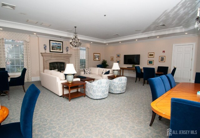 carpeted living room featuring ornamental molding, a tray ceiling, and a notable chandelier