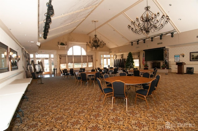 carpeted dining room with high vaulted ceiling and a chandelier