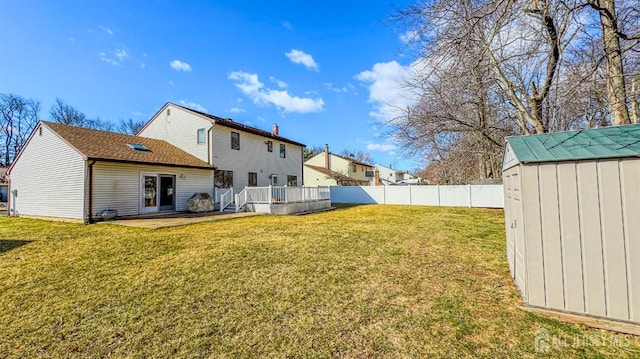 rear view of property with a patio area, an outbuilding, fence, a storage shed, and a yard
