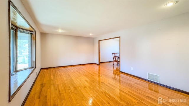 spare room featuring light wood-type flooring, recessed lighting, baseboards, and visible vents