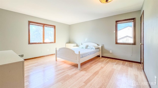 bedroom with baseboards and light wood finished floors