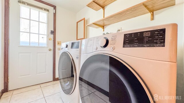washroom with washing machine and dryer, laundry area, and light tile patterned floors
