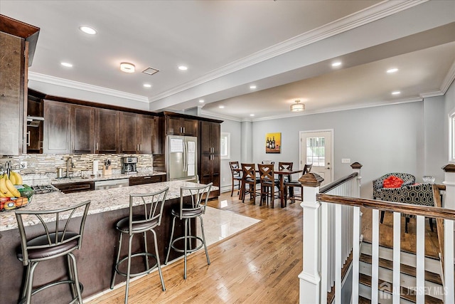 5 Alvin Ct, Menlo Park Terrace, NJ 08840 - kitchen with freestanding refrigerator, dark brown cabinetry, light wood-type flooring, light stone countertops, and a breakfast bar area