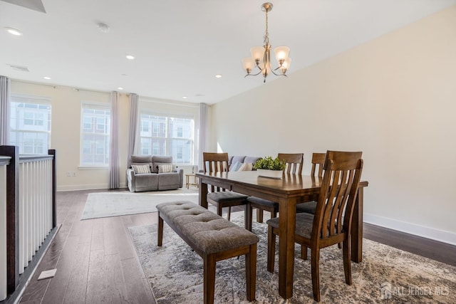 dining area with visible vents, dark wood finished floors, baseboards, and an inviting chandelier