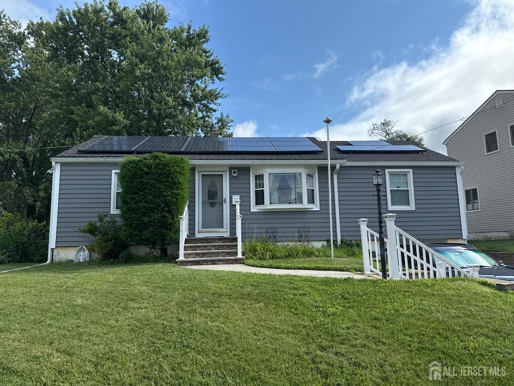 38 Victory Pl E, Brunswick, NJ 08816 - view of front of home featuring solar panels and a front lawn