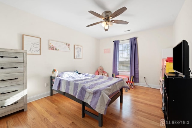 bedroom with light wood-type flooring, visible vents, and baseboards