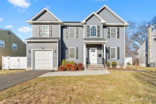 view of front of property with aphalt driveway, an attached garage, a gate, fence, and a front yard