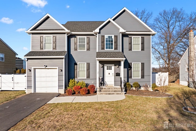 view of front of house featuring aphalt driveway, a garage, fence, a gate, and a front lawn