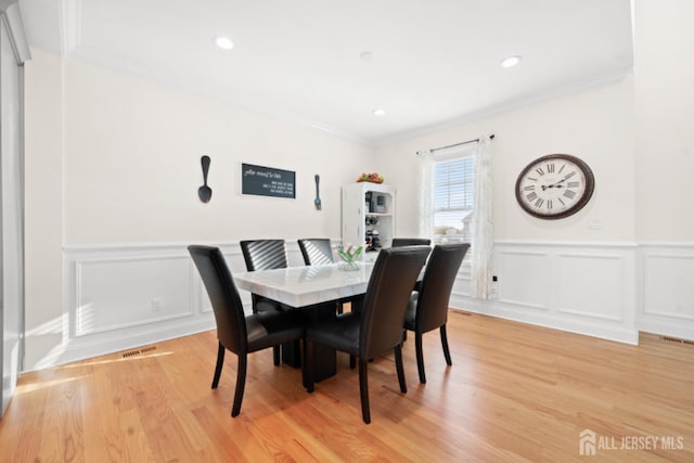 dining area featuring light wood finished floors, visible vents, crown molding, and recessed lighting