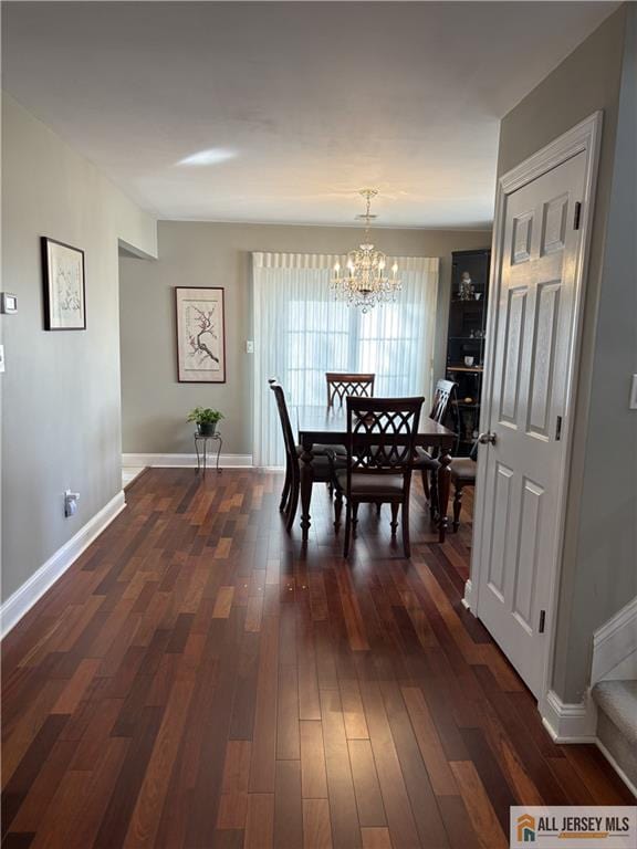 dining area with baseboards, an inviting chandelier, and dark wood-style floors