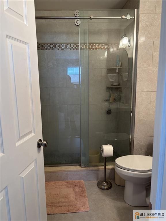 bathroom with a shower stall and toilet