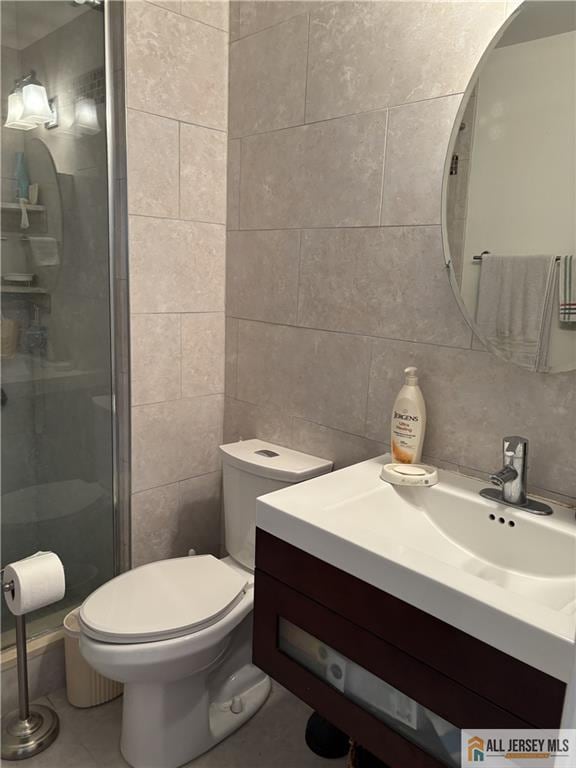 bathroom featuring toilet, a stall shower, tile walls, decorative backsplash, and vanity