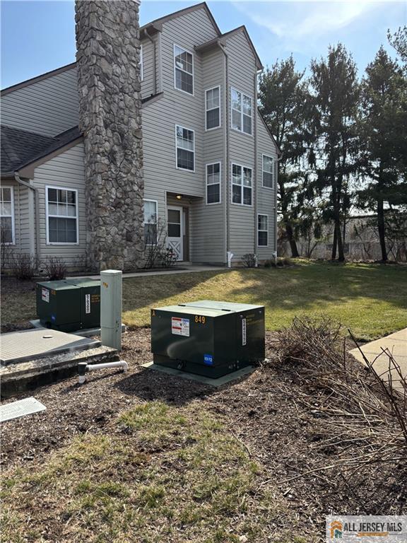 rear view of property featuring a lawn and a chimney