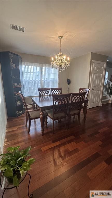 dining room featuring an inviting chandelier, hardwood / wood-style flooring, and visible vents