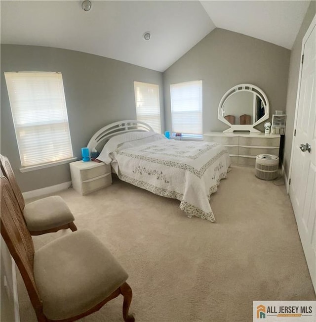 carpeted bedroom with lofted ceiling