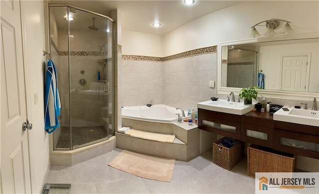 bathroom with a sink, tile patterned flooring, a shower stall, and a garden tub