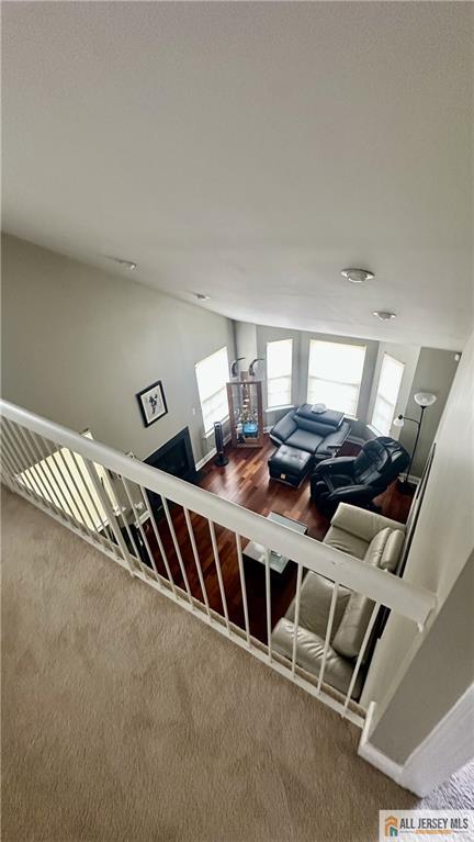 stairway with carpet flooring and lofted ceiling