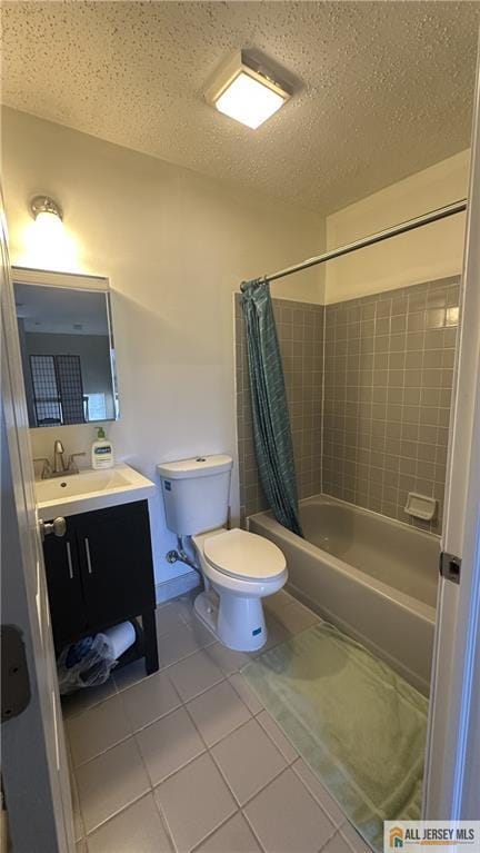 full bathroom featuring shower / bath combo with shower curtain, vanity, toilet, a textured ceiling, and tile patterned floors