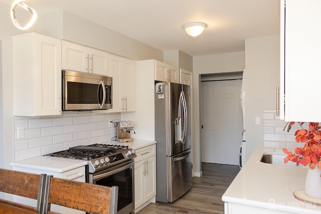 kitchen with stainless steel appliances, wood finished floors, and light countertops