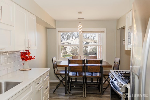 dining space with dark wood-style flooring and baseboards