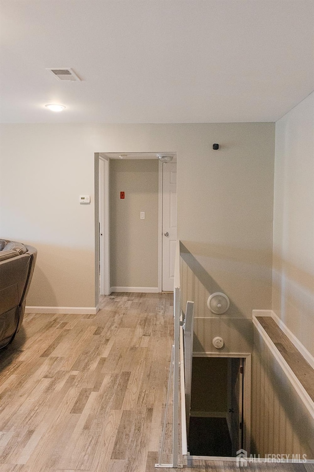 corridor featuring light wood-style floors and baseboards