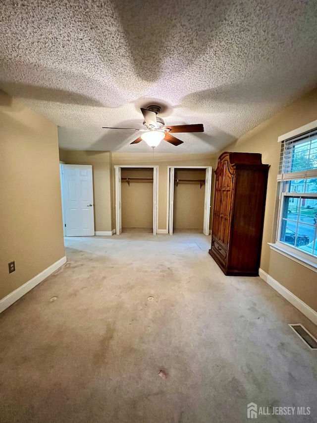 37 Albury Way N, Brunswick, NJ 08902 - unfurnished bedroom featuring multiple closets, a textured ceiling, carpet, and a ceiling fan
