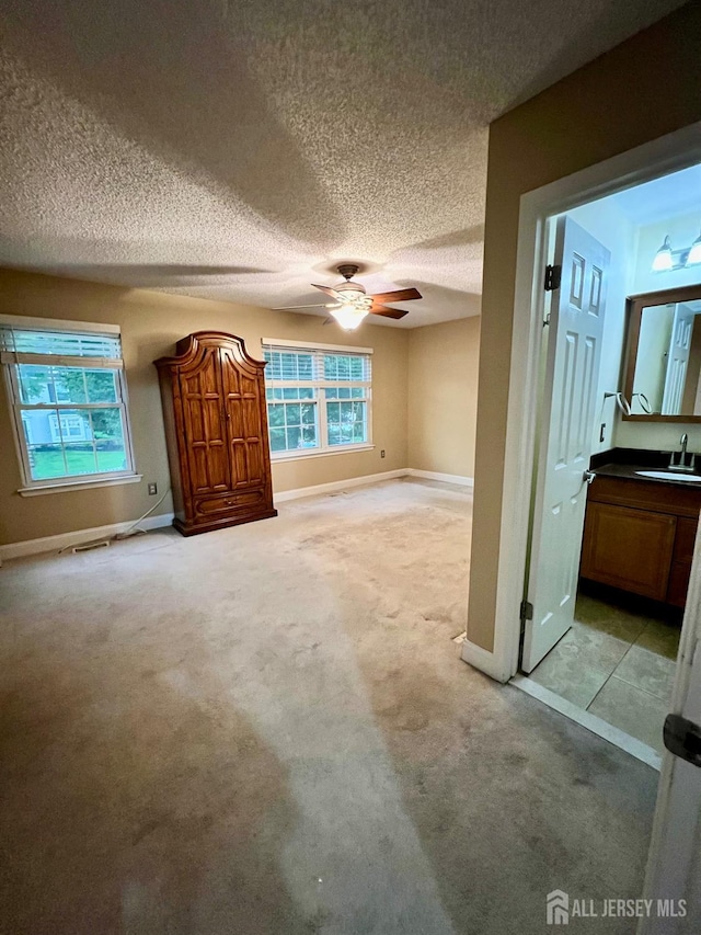 37 Albury Way N, Brunswick, NJ 08902 - unfurnished living room with a textured ceiling, a ceiling fan, and light carpet