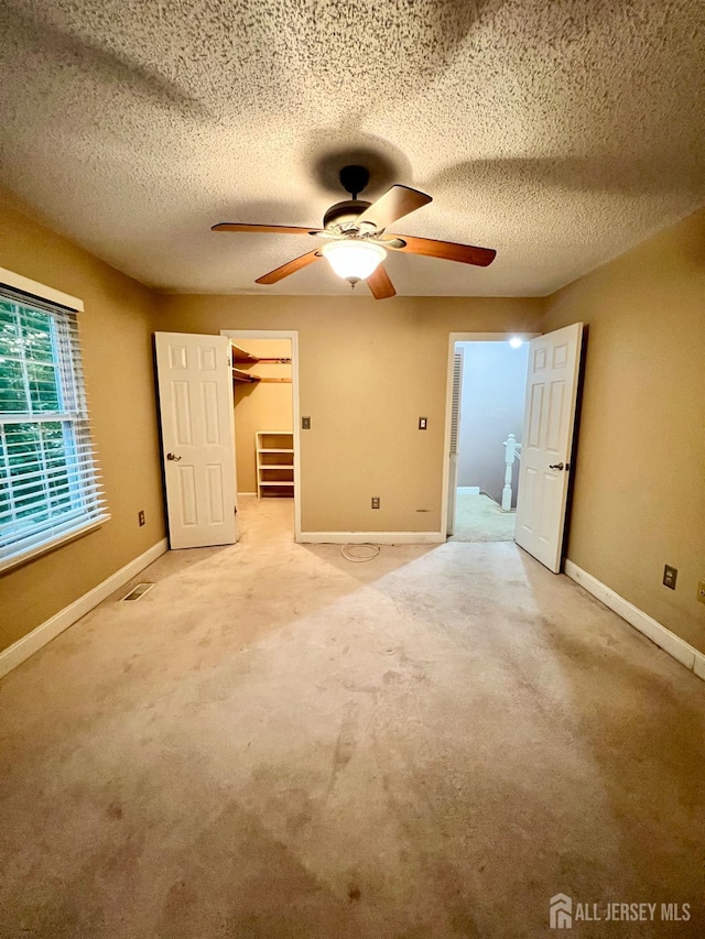 37 Albury Way N, Brunswick, NJ 08902 - unfurnished bedroom with ceiling fan, a textured ceiling, a spacious closet, and light colored carpet