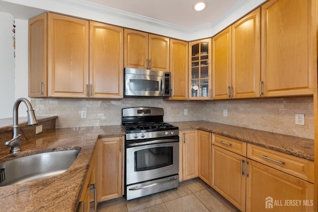 kitchen with light tile patterned floors, glass insert cabinets, a sink, stainless steel appliances, and backsplash