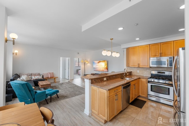 kitchen with open floor plan, a peninsula, a sink, stainless steel appliances, and backsplash