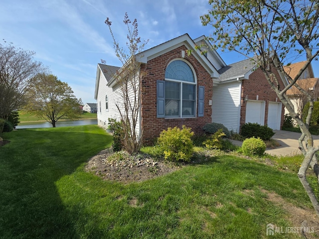 16 Phillip Ct, Monroe, NJ 08831 - view of front facade featuring brick siding, a water view, a front yard, a garage, and concrete driveway