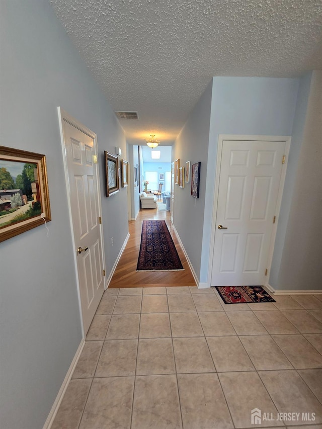 16 Phillip Ct, Monroe, NJ 08831 - hallway featuring light tile patterned floors, a textured ceiling, and baseboards