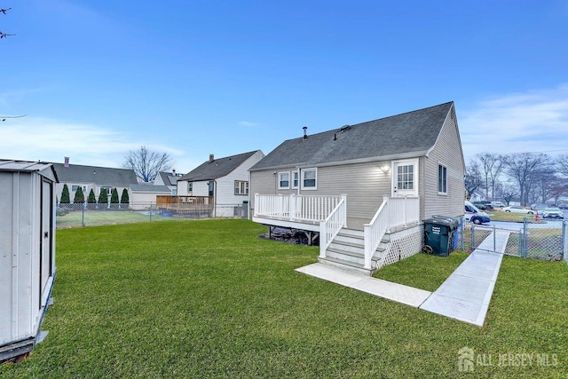 back of house featuring a deck, a yard, a fenced backyard, and a residential view